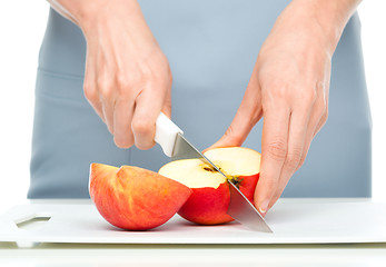 Image showing Cook is chopping red apple