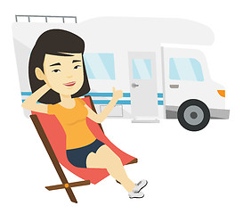 Image showing Woman sitting in chair in front of camper van.