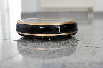 Image showing Robotic vacuum cleaner on bright marble floor