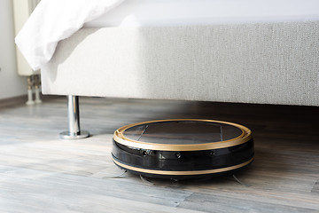 Image showing Robot vacuum cleaner runs under bed