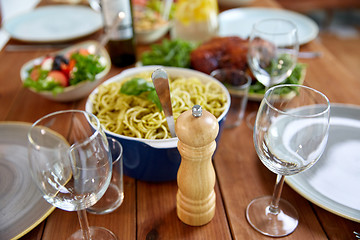 Image showing pepper mill or salt grinder on served wooden table