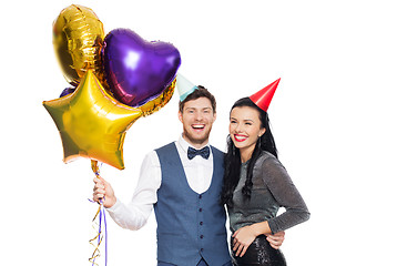 Image showing happy couple with party caps and balloons