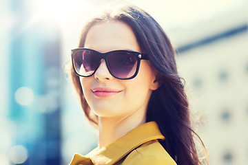 Image showing smiling young woman with sunglasses in city