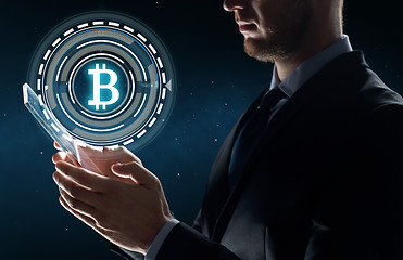 Image showing businessman with tablet pc and bitcoin hologram