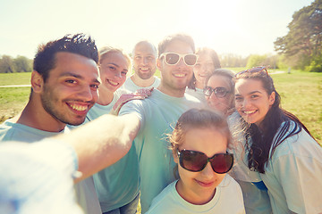 Image showing group of volunteers taking selfie by smartphone