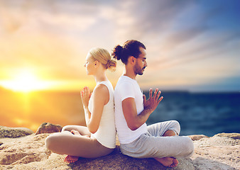 Image showing happy couple making yoga and meditating outdoors