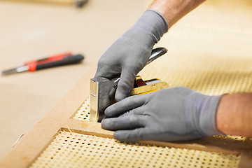 Image showing assembler with staple gun making furniture