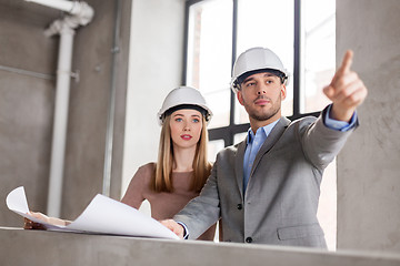 Image showing architects with blueprint and helmets at office