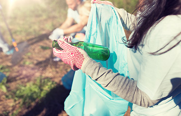 Image showing volunteer with trash bag and bottle cleaning area