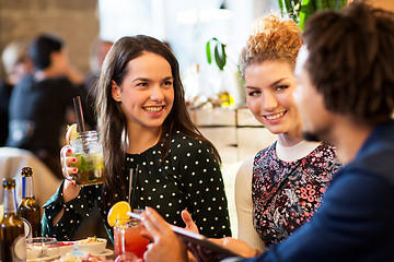 Image showing happy friends eating and drinking at restaurant