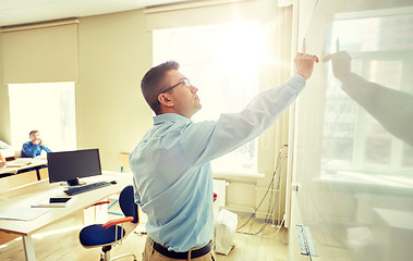 Image showing students and teacher writing on school white board