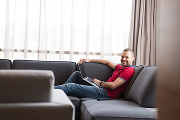 Image showing Man using laptop in living room