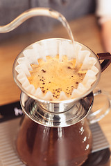 Image showing Hand drip coffee, Barista pouring water on coffee ground with filter