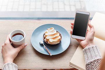 Image showing Cup of coffee, branch of tree, wooden windowsill