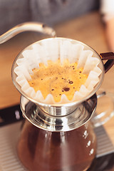 Image showing Hand drip coffee, Barista pouring water on coffee ground with filter