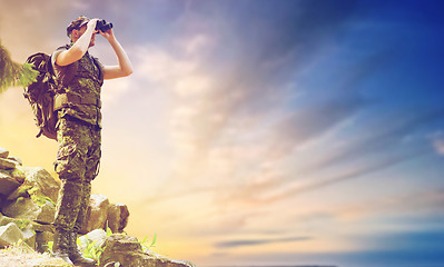 Image showing soldier with backpack looking to binocular