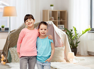 Image showing happy smiling little girls hugging at home