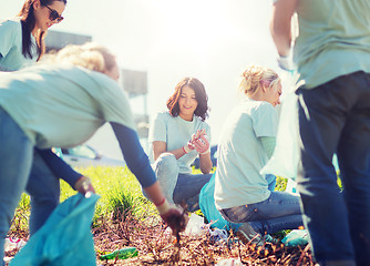 Image showing volunteers with garbage bags cleaning park area