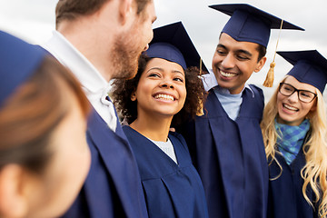 Image showing happy students or bachelors in mortar boards