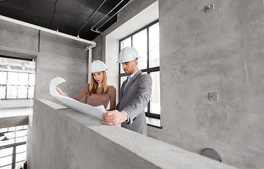 Image showing architects with blueprint and helmets at office