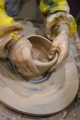 Image showing Hands of young girl in process of making crockery on pottery whe