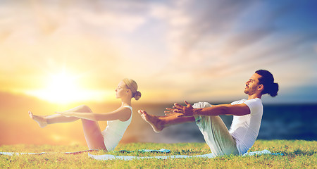 Image showing couple making yoga half-boat pose outdoors