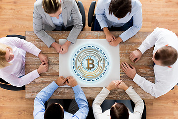 Image showing business team at table with bitcoin icon