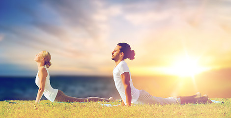 Image showing couple making yoga cobra pose outdoors