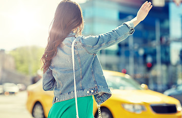 Image showing young woman or girl catching taxi on city street