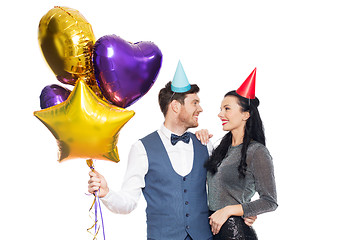 Image showing happy couple with party caps and balloons