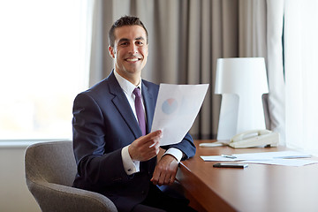 Image showing businessman with papers working at hotel room