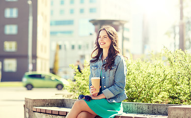 Image showing happy young woman drinking coffee on city street