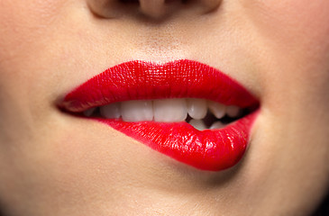 Image showing close up of woman with red lipstick biting lip