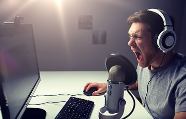 Image showing man in headset playing computer video game at home