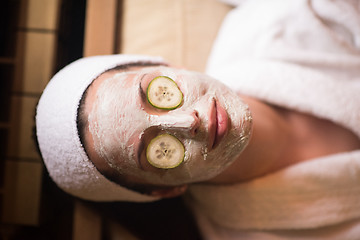 Image showing woman is getting facial clay mask at spa