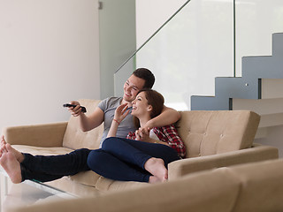 Image showing Young couple on the sofa watching television