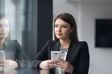 Image showing Business Girl Standing In A Modern Building Near The Window With