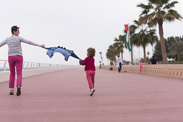 Image showing mother and cute little girl on the promenade by the sea