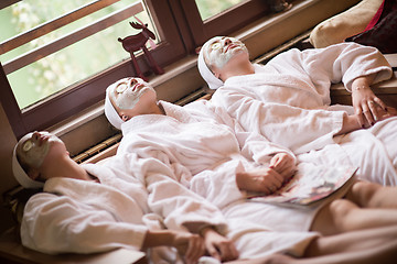 Image showing women is getting facial clay mask at spa