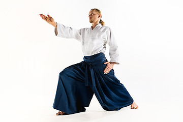 Image showing Aikido master practices defense posture. Healthy lifestyle and sports concept. Man with beard in white kimono on white background.