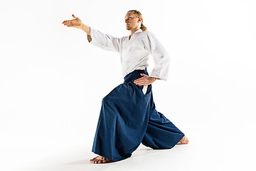 Image showing Aikido master practices defense posture. Healthy lifestyle and sports concept. Man with beard in white kimono on white background.