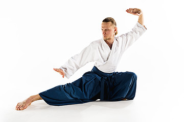 Image showing Aikido master practices defense posture. Healthy lifestyle and sports concept. Man with beard in white kimono on white background.