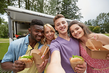 Image showing happy friends taking selfie at food truck