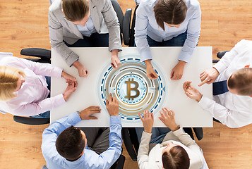 Image showing business team at table with bitcoin icon