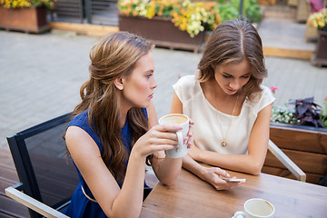 Image showing young women with smartphone and coffee at cafe