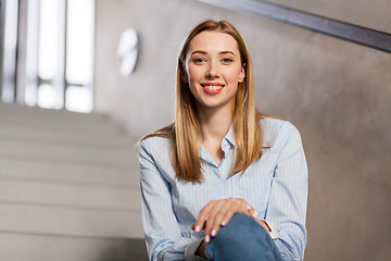 Image showing happy smiling woman or student sitting on stairs