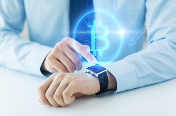 Image showing close up of hands with bitcoin on smart watch