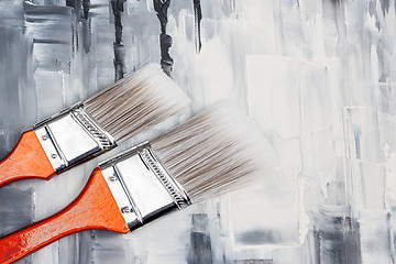 Image showing Two paint brushes on artistic canvas