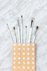 Image showing White paint brushes in a decorative paper bag