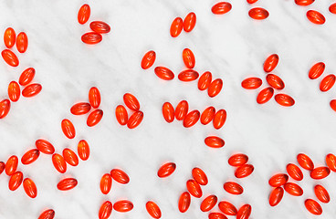 Image showing Red shiny pills on marble background